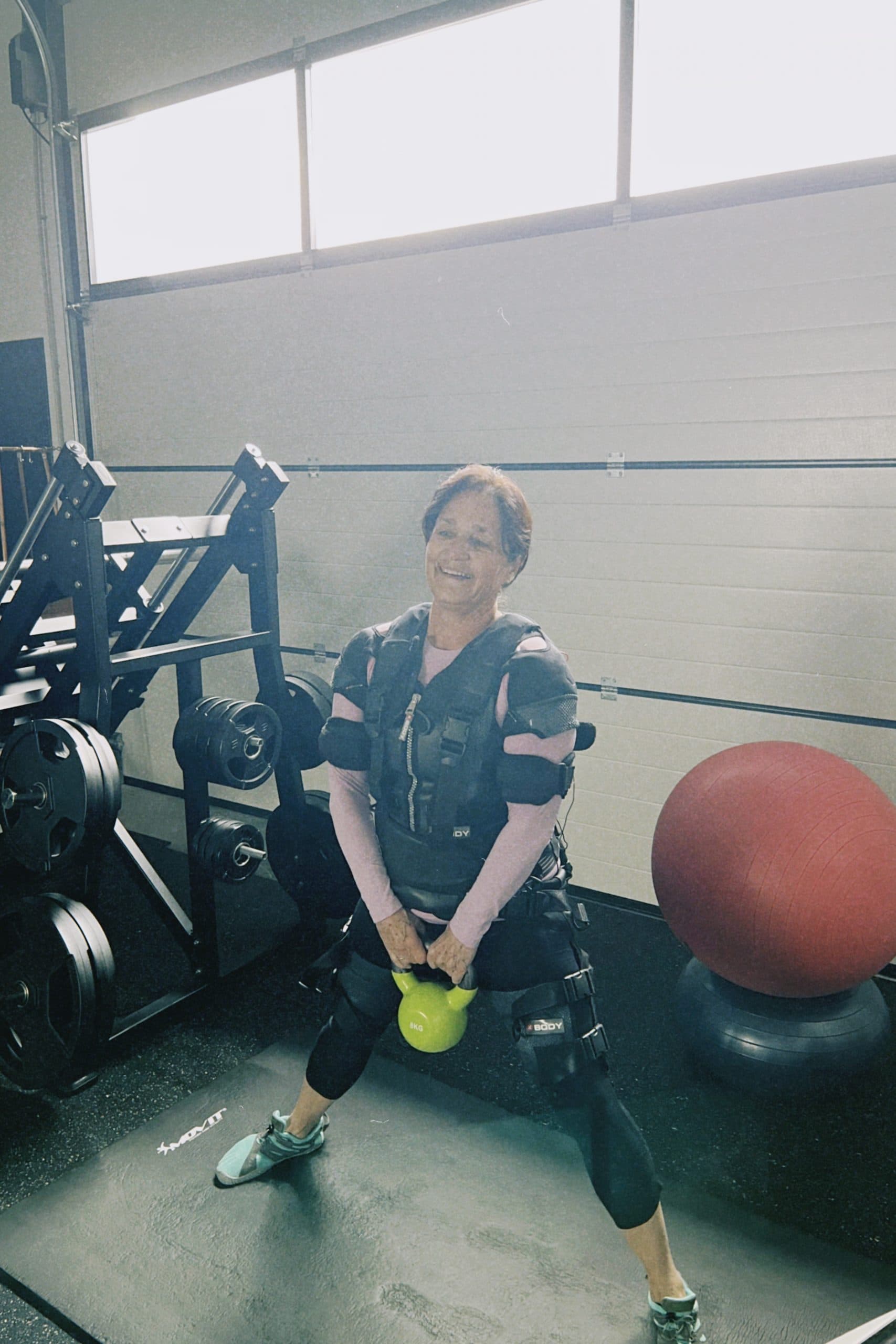 Kundin beim EMS-Training mit Kettlebell